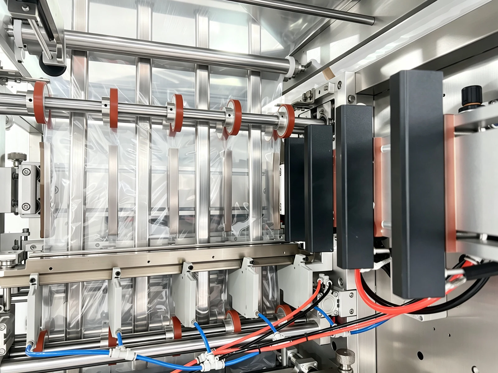 Film, guide rollers, forming and sealing assemblies inside a packaging machine